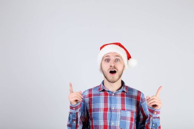 Noel Baba şapkası gri arka plan üzerinde genç adam