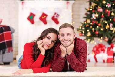 Genç çift evde yılbaşı ağacının yanında yalan