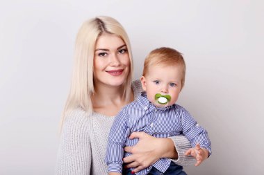 Anne ve bebek çocuk gri arka plan üzerinde gülümseyen