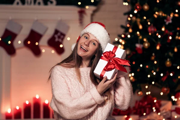 Молодая Девушка Шляпе Санты Подарочной Коробкой Возле Рождественской Елки Дома — стоковое фото
