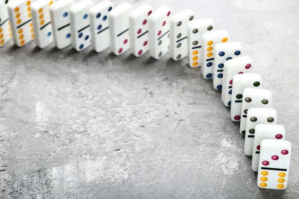 Dominoes in a row on grey wooden table