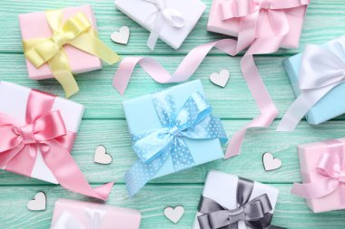 Ahşap masa üzerinde küçük beyaz yürekleri renkli hediye kutuları