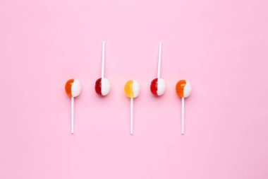 Pembe bir arka plan üzerinde tatlı lolipop