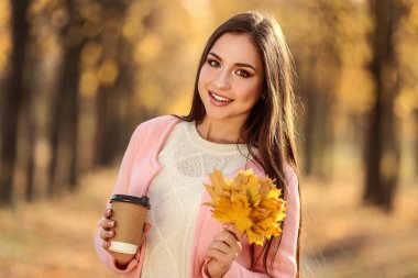 Güzel kadın ile akçaağaç yaprakları ve Kupası Sonbahar Park kağıt