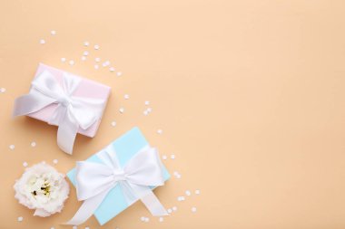 Bej renkli arka plan üzerinde şerit ve eustoma çiçek hediye kutuları