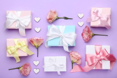 Hediye kutuları eustoma çiçekler mor zemin üzerine