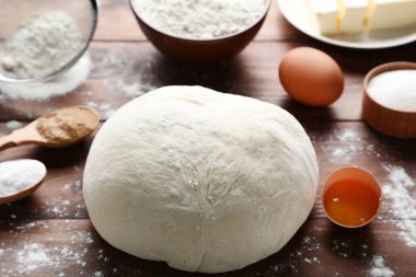 Yumurta ve un üzerinde ahşap masa ile çiğ hamur