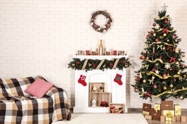 Şömine kanepe ve Noel ağacı tuğla duvar arka plan üzerinde beyaz dekore