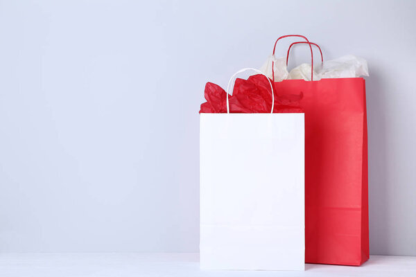 Colorful paper shopping bags on grey background