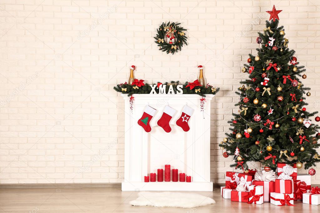 White fireplace with christmas tree on brick wall background