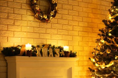 Şömine yakınındaki Noel ağacı tuğla duvar arka plan üzerinde beyaz dekore