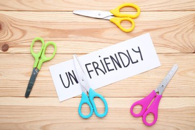 Word Unfriendly ile kağıt ve renkli makaslar ahşap masa
