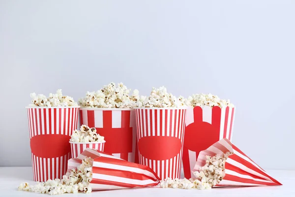 Popcorn Gestreiften Eimern Und Papiertüten Auf Grauem Hintergrund — Stockfoto