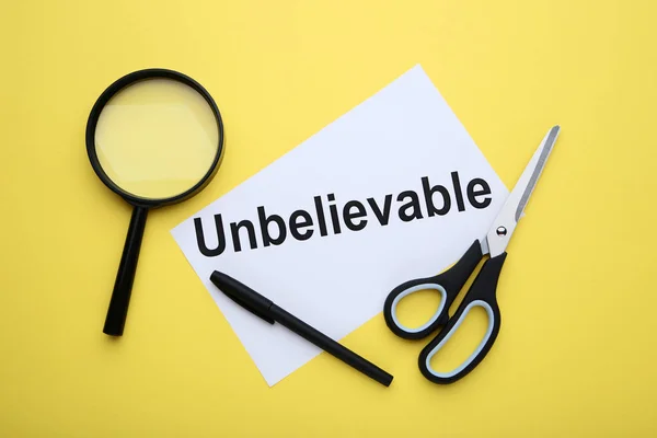 Paper Word Unbelievable Scissors Magnifying Glass Yellow Background — Stock Photo, Image