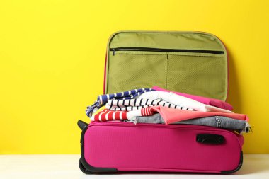 Pembe çanta sarı arka plan üzerinde elbise ile açıldı