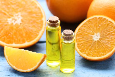 Mavi ahşap masa üzerinde şişelerde portakal yağı