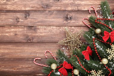 Süslemeleri ve şekerler kahverengi ahşap masa üzerinde Noel köknar ağacı dalları