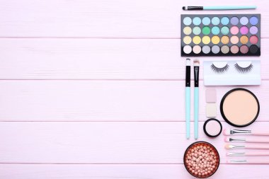 Pembe ahşap masa üzerinde farklı makyaj kozmetik