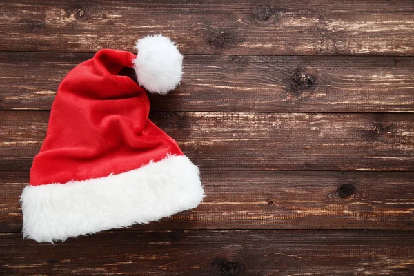 棕色木桌上的圣诞老人帽子 — 图库照片