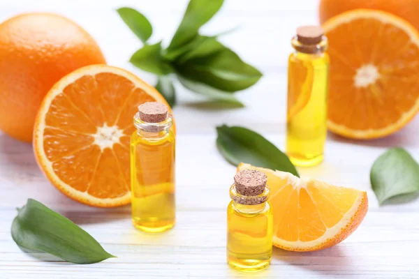 Aceite Naranja Botellas Con Hojas Verdes Sobre Mesa Madera —  Fotos de Stock