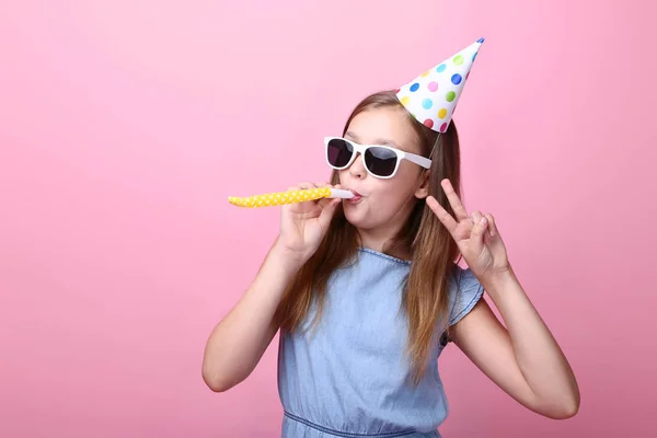 Niedliches Junges Mädchen Mit Geburtstagsmütze Und Trillerpfeife Auf Rosa Hintergrund — Stockfoto