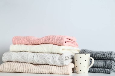 Gri arka plan üzerinde cup ile katlanmış kazak yığını