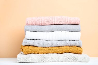 Bej renkli arka plan üzerinde katlanmış kazak yığını