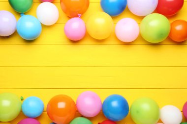 Sarı ahşap masa üzerinde renkli balonlar