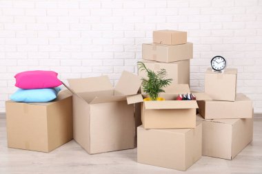 Tuğla duvar arka plan üzerinde ev malzeme ile karton kutular