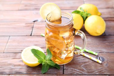Buzlu çay cam ahşap masa üzerinde limon ve nane yaprakları ile