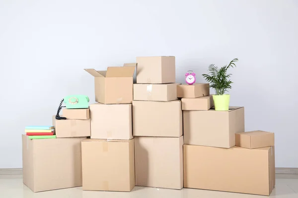 Cardboard boxes with household stuff on grey background