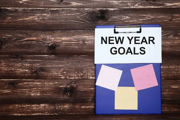 New year goals on sheet of paper with blue clipboard