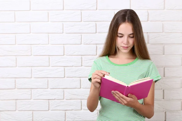 Jovem Com Livro Sobre Fundo Parede Tijolo Branco — Fotografia de Stock