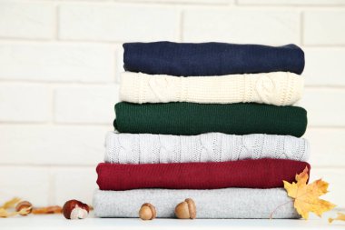 Tuğla duvar arka plan üzerinde yığın katlanmış kazak meşe palamutları, kestane ve sonbahar yaprakları