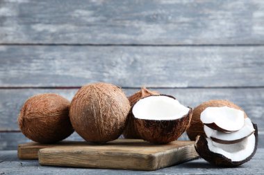 Kesme tahtası üzerinde gri ahşap masa ile olgunlaşmış hindistancevizi