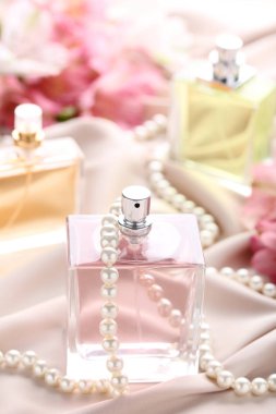 Parfüm şişesi ile saten zemin üzerine boncuk