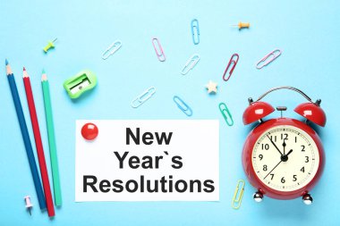 Yeni yıl kararları kağıda renkli klipleri, kalemler ve çalar saat