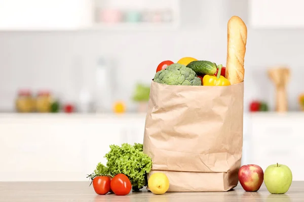 Grocery shopping bag with food on wooden table