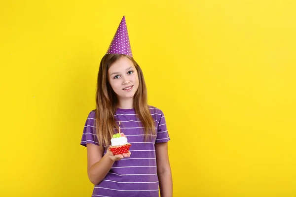 Jovencita Sombrero Cumpleaños Sosteniendo Cupcake Con Vela Sobre Fondo Amarillo — Foto de Stock