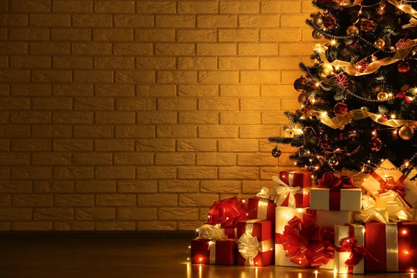 Dekorasyon ve tuğla duvar arka plan üzerinde hediye kutuları ile Noel ağacı