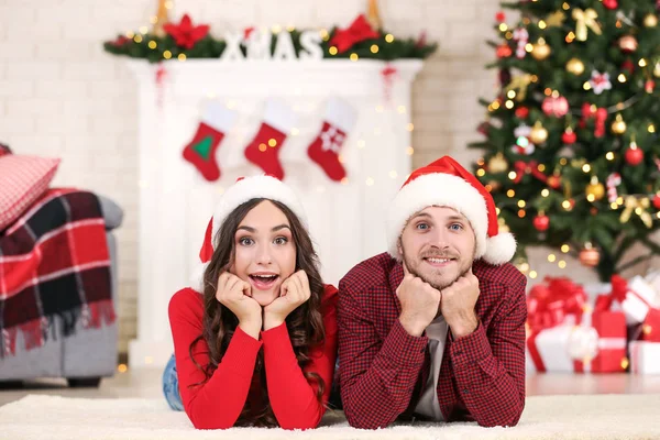 Pareja Joven Sombreros Santa Mentira Casa Cerca Del Árbol Navidad — Foto de Stock