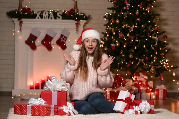 年轻的女孩坐在圣诞树附近的礼物盒在家里 — 图库照片