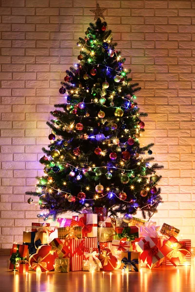 Árbol Navidad Con Decoraciones Cajas Regalo Sobre Fondo Pared Ladrillo — Foto de Stock