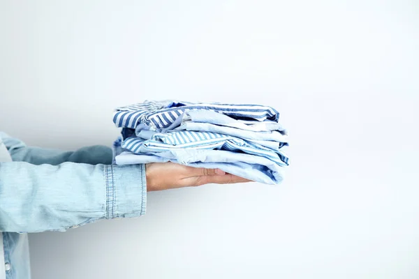 Female Hands Holding Folded Shirts — Stock Photo, Image