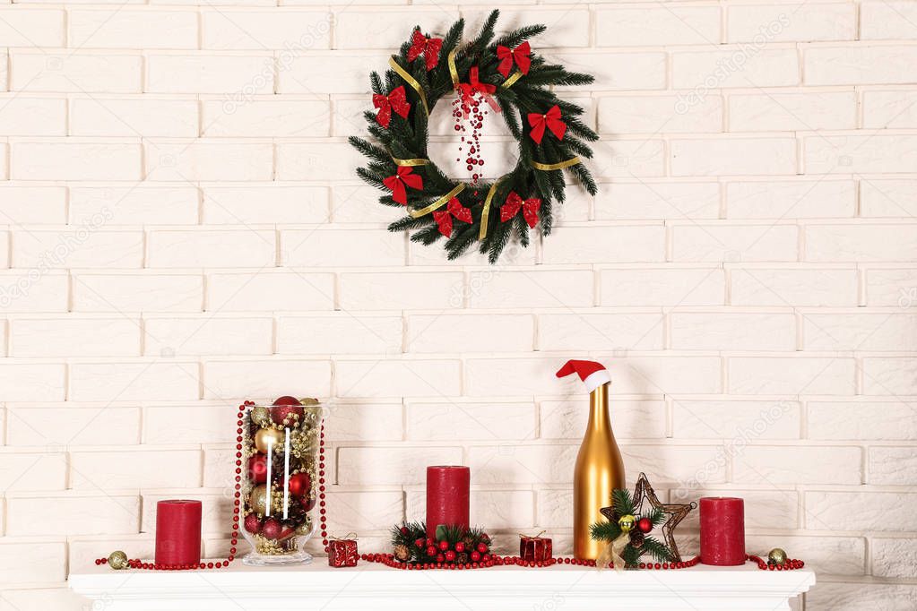 White decorated fireplace with wreath on brick wall background