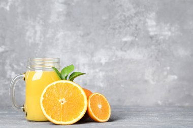 Eski püskü gri arka plan üzerinde cam kavanoza portakal suyu