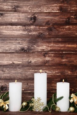 Köknar ağaç dalları ve baubles kahverengi zemin üzerine beyaz Noel mumlar