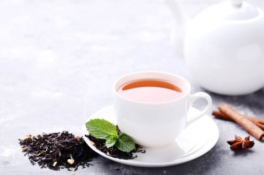 Çay nane ile yapraklar ve gri ahşap masanın üzerine tarçın sopa