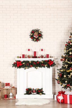 Şömine yakınındaki Noel ağacı tuğla duvar arka plan üzerinde beyaz dekore