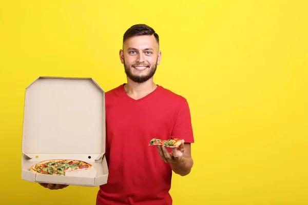 Jonge Man Eten Van Pizza Houden Kartonnen Doos Gele Achtergrond — Stockfoto